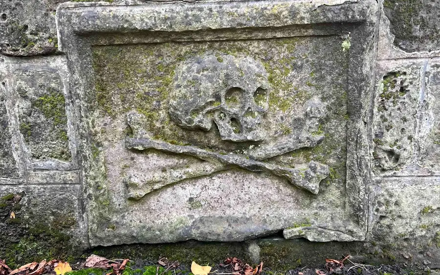 A weathered skull-and-crossbones gravestone in an Edinburgh kirkyard