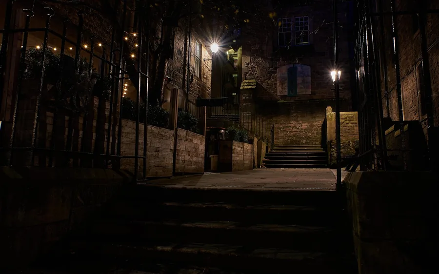Dark closes off the Royal Mile lit by street lamps at night